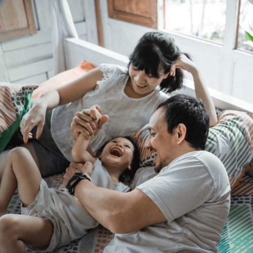 Parents and child playing on the couch